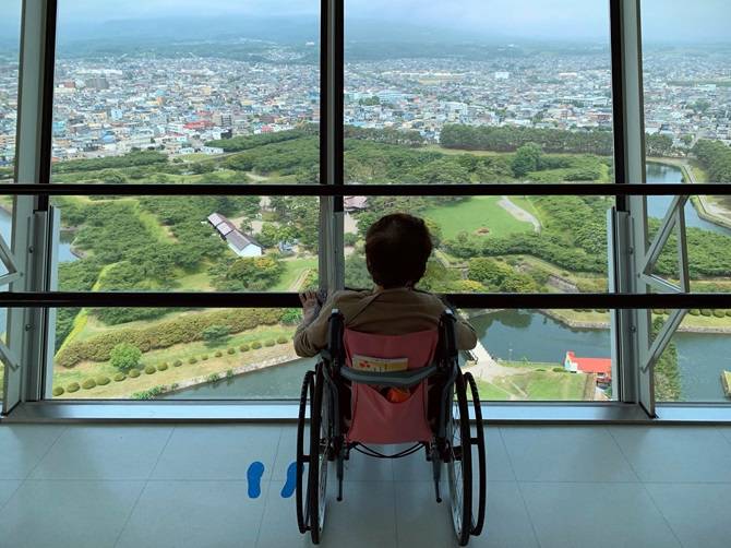 五稜郭タワー展望階から景色を見下ろす車椅子の母