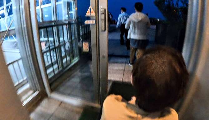 【函館山ロープウェイ】漁火公園への出入口の自動ドアを車いすで通る様子